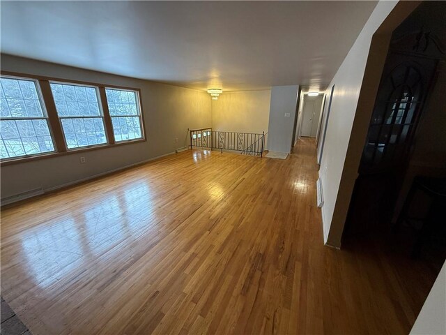 spare room with hardwood / wood-style floors and a baseboard heating unit