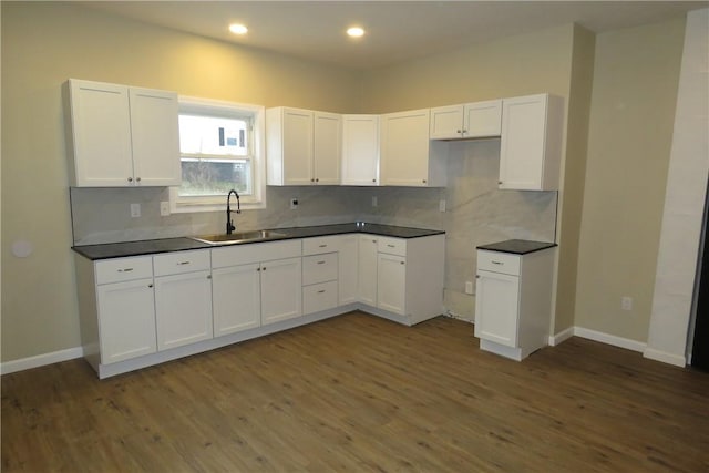 kitchen featuring dark hardwood / wood-style floors, white cabinetry, sink, and tasteful backsplash