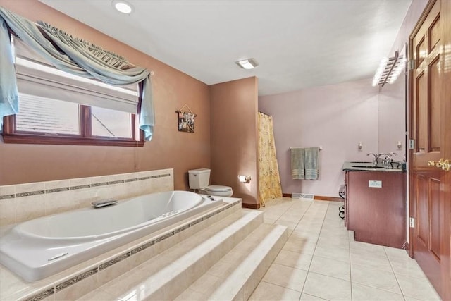 bathroom with tile patterned flooring, vanity, toilet, and tiled bath