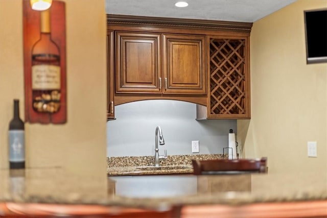 kitchen with light stone counters and a sink