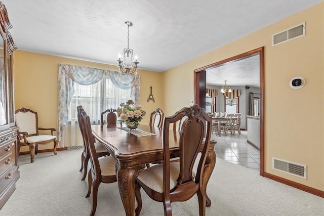 carpeted dining area with an inviting chandelier