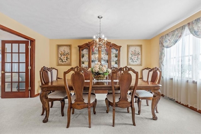 dining space with light carpet and an inviting chandelier