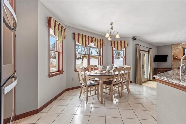 dining room with plenty of natural light, light tile patterned floors, and an inviting chandelier