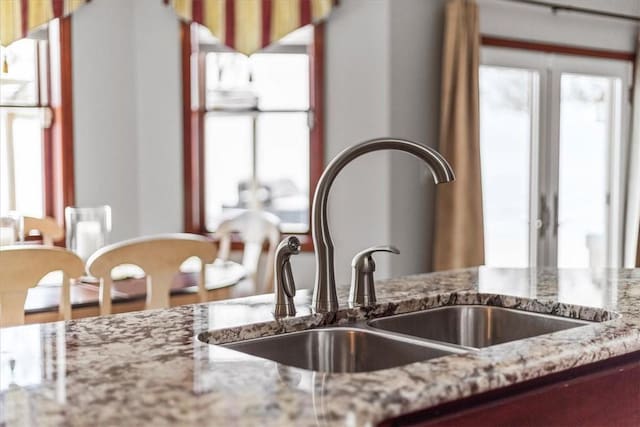 room details featuring light stone counters and sink