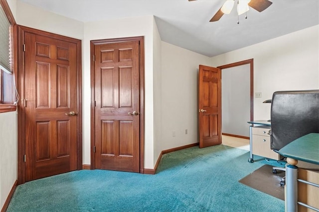 unfurnished office featuring carpet, a ceiling fan, and baseboards