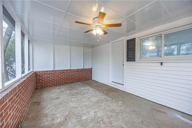 unfurnished sunroom featuring ceiling fan