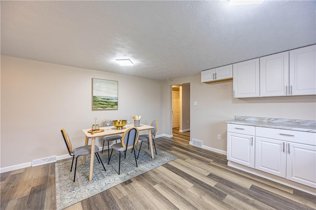 dining area featuring light hardwood / wood-style floors and a textured ceiling