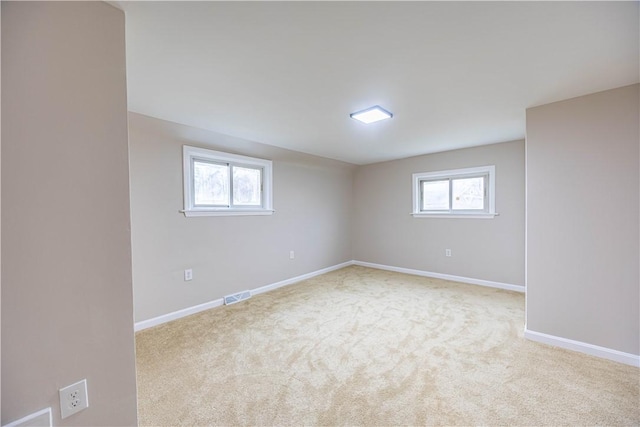 basement with a healthy amount of sunlight and light carpet