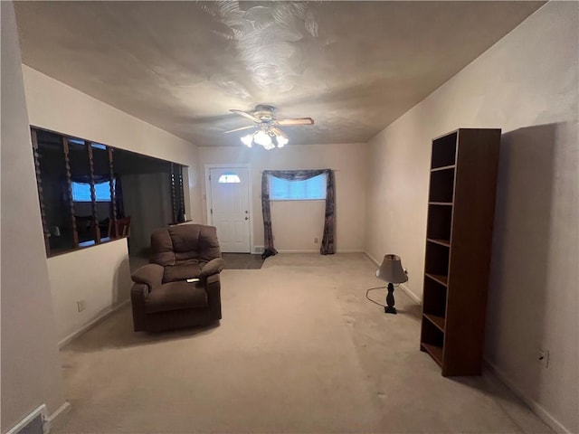 sitting room with ceiling fan and light colored carpet