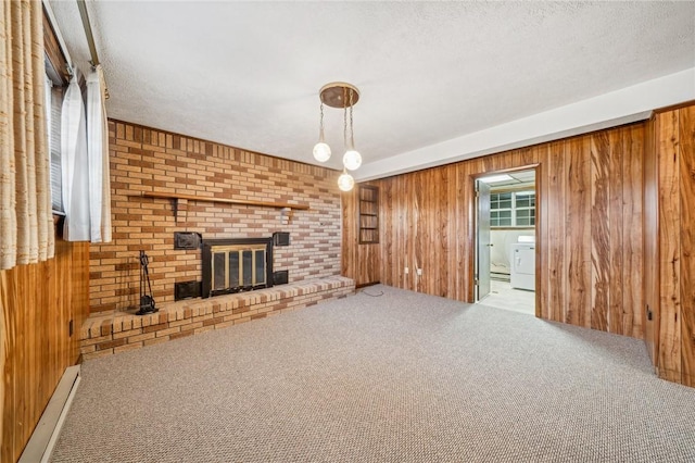 unfurnished living room with a textured ceiling, light carpet, wooden walls, and a baseboard heating unit