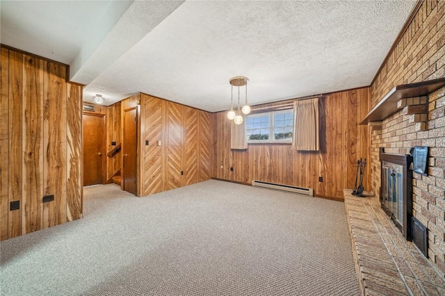 unfurnished living room with carpet flooring, a fireplace, wooden walls, and a baseboard heating unit