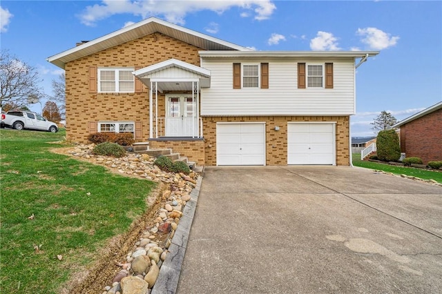 bi-level home featuring a garage and a front lawn