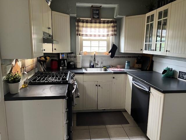 kitchen featuring decorative backsplash, light tile patterned floors, stainless steel appliances, and sink