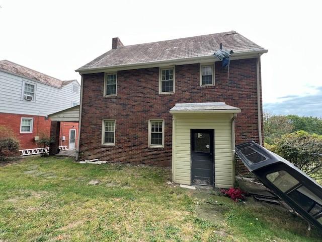 rear view of property featuring a lawn