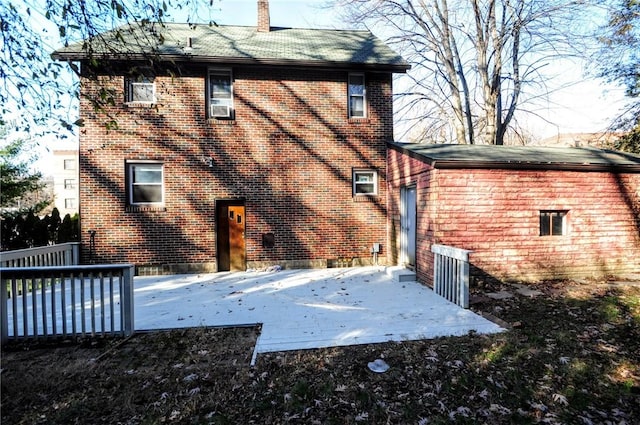 back of property featuring a wooden deck and a patio