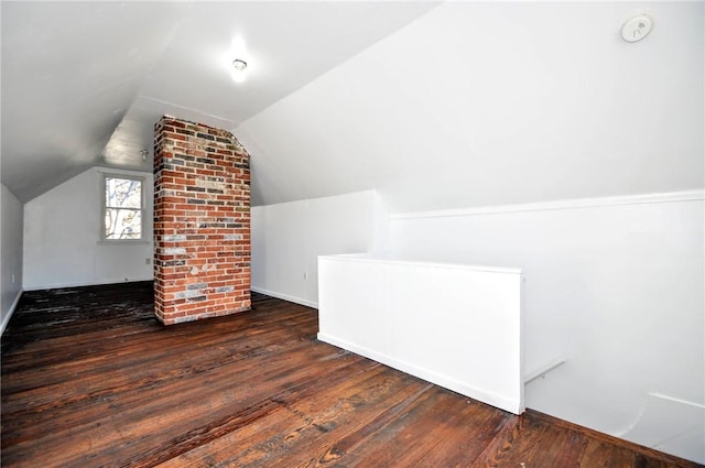 additional living space featuring vaulted ceiling and dark hardwood / wood-style floors