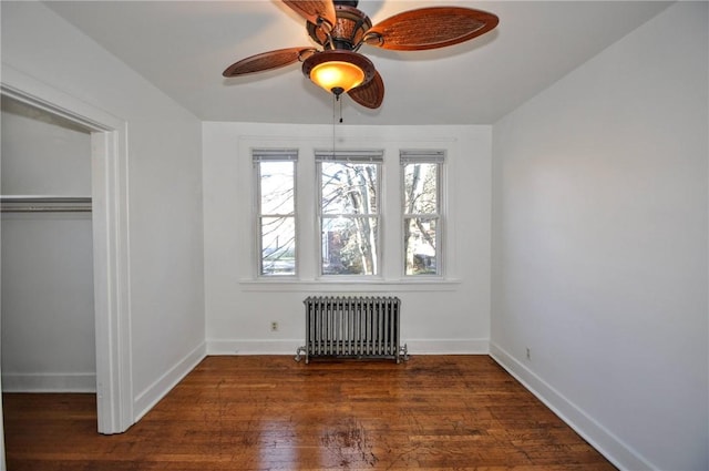 unfurnished bedroom with ceiling fan, dark hardwood / wood-style flooring, and radiator heating unit