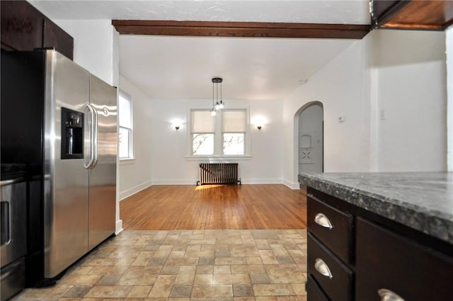 kitchen featuring dark brown cabinetry, radiator, stainless steel refrigerator with ice dispenser, light hardwood / wood-style floors, and decorative light fixtures