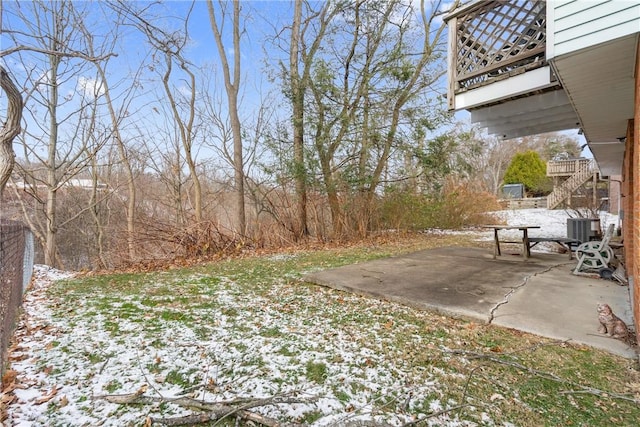 yard layered in snow with a patio and cooling unit