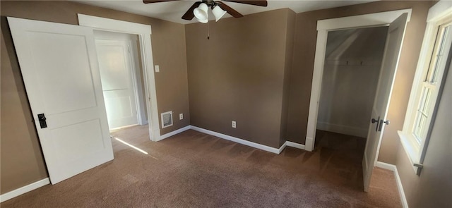 unfurnished bedroom with dark colored carpet, ceiling fan, and a closet