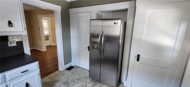 kitchen featuring white cabinets, stainless steel fridge, and light hardwood / wood-style flooring