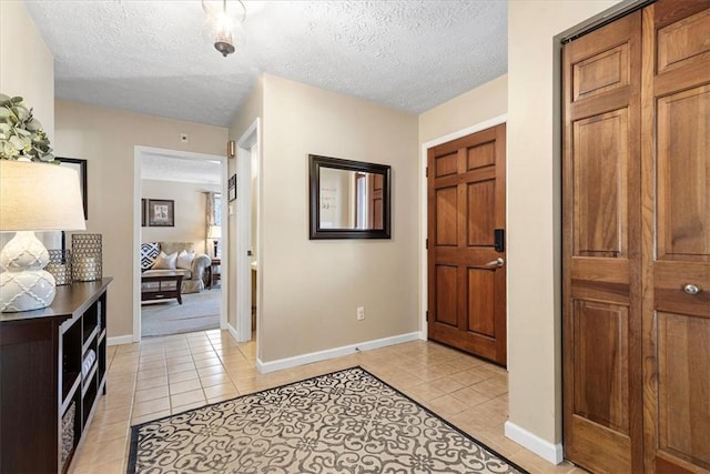 foyer with light tile patterned floors and a textured ceiling