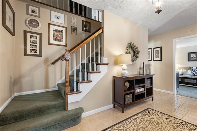 stairs featuring tile patterned flooring and a textured ceiling