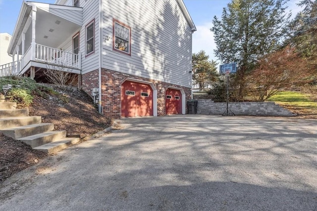 view of property exterior featuring a porch and a garage