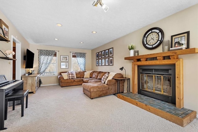 living room with a textured ceiling, carpet floors, and a fireplace