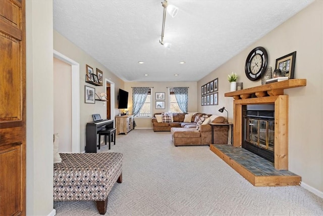 living room featuring a textured ceiling, carpet floors, and a fireplace