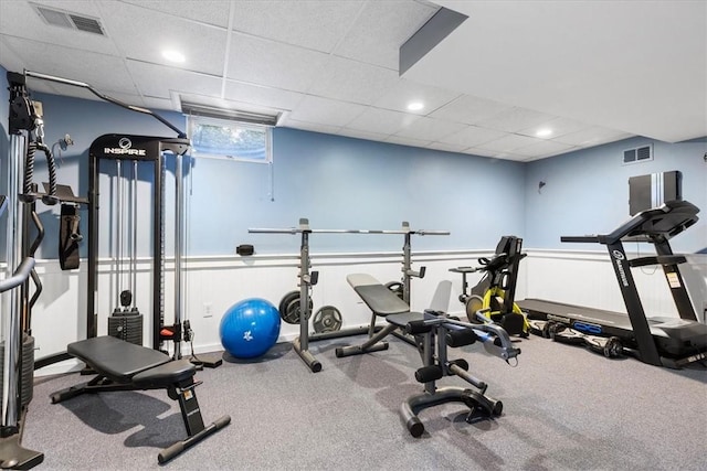 workout area featuring a paneled ceiling and carpet floors