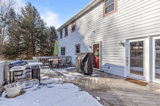 snow covered deck with a grill