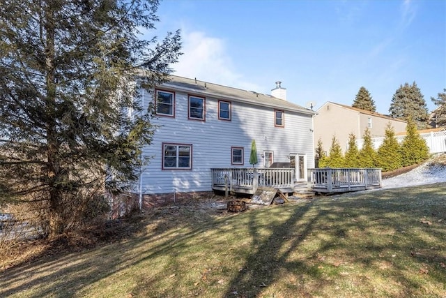 rear view of property featuring a yard and a deck