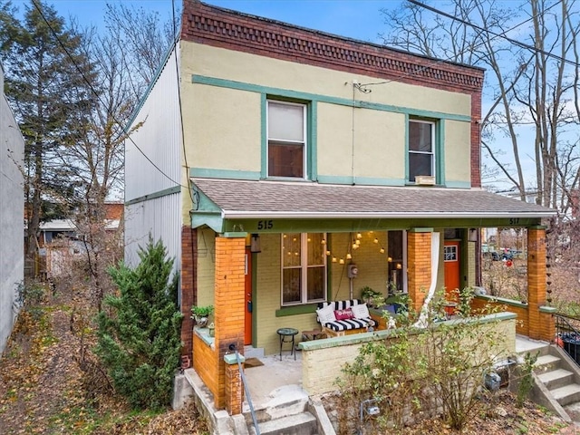 rear view of house featuring covered porch