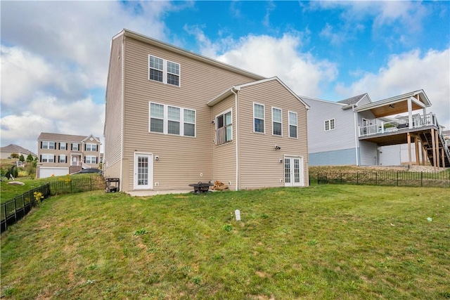 rear view of property with french doors and a lawn