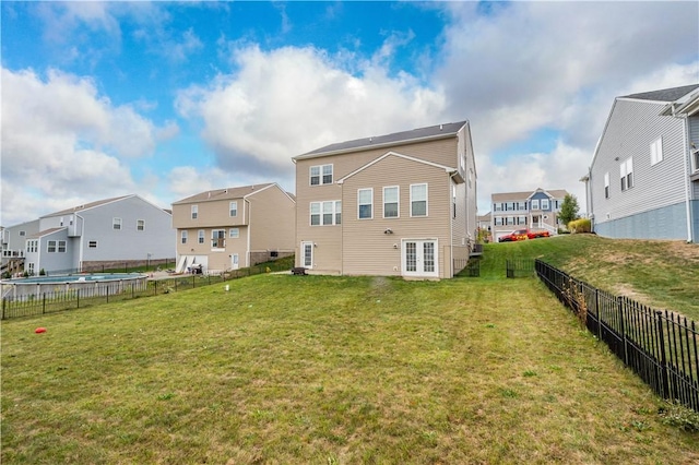 rear view of property with a lawn and french doors