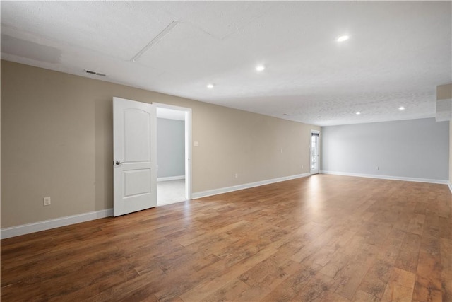 unfurnished room with wood-type flooring and a textured ceiling