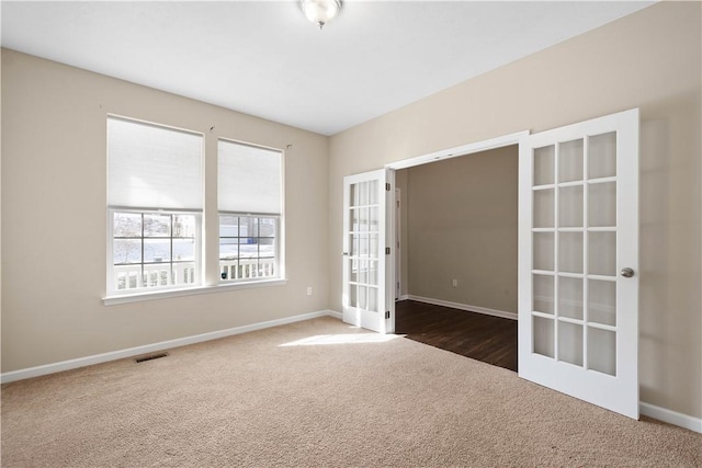 carpeted spare room with french doors