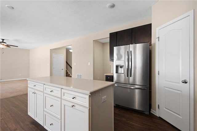 kitchen featuring white cabinetry, a center island, ceiling fan, dark hardwood / wood-style flooring, and stainless steel fridge