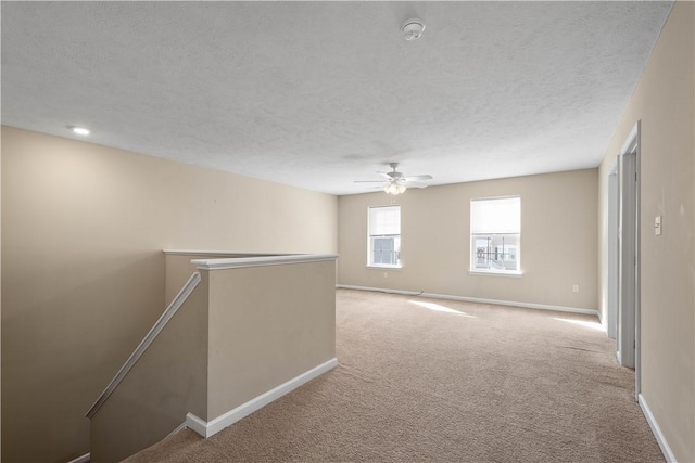 carpeted spare room with ceiling fan and a textured ceiling