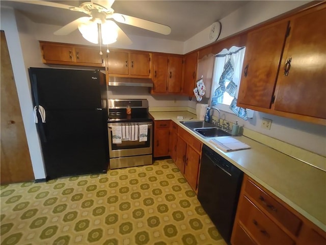 kitchen with brown cabinets, under cabinet range hood, light countertops, black appliances, and a sink