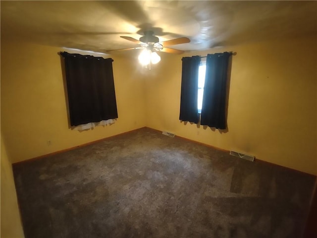 unfurnished room with a ceiling fan, visible vents, and carpet floors