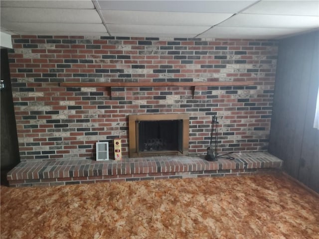 room details featuring a paneled ceiling and a brick fireplace