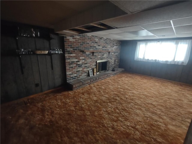 basement featuring a paneled ceiling, carpet, and a fireplace