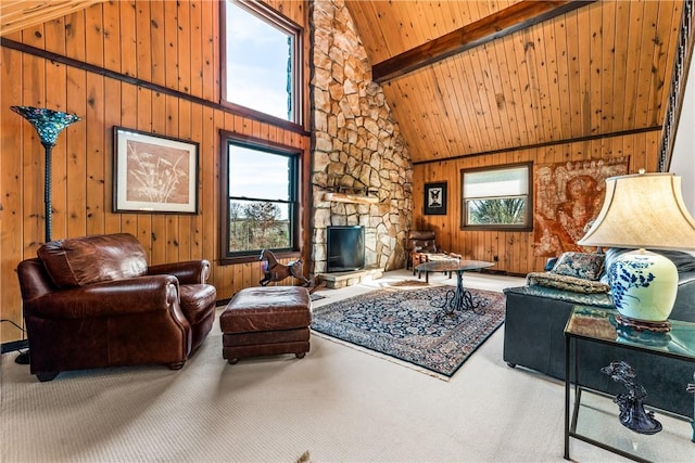 carpeted living room featuring beam ceiling, high vaulted ceiling, a healthy amount of sunlight, and a stone fireplace