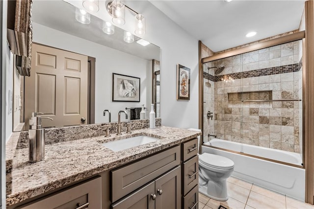 full bathroom with tile patterned flooring, toilet, combined bath / shower with glass door, and vanity