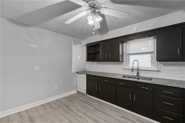 kitchen featuring light stone countertops, ceiling fan, dishwasher, sink, and light hardwood / wood-style floors