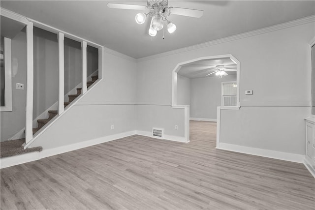 empty room with ceiling fan, light wood-type flooring, and ornamental molding