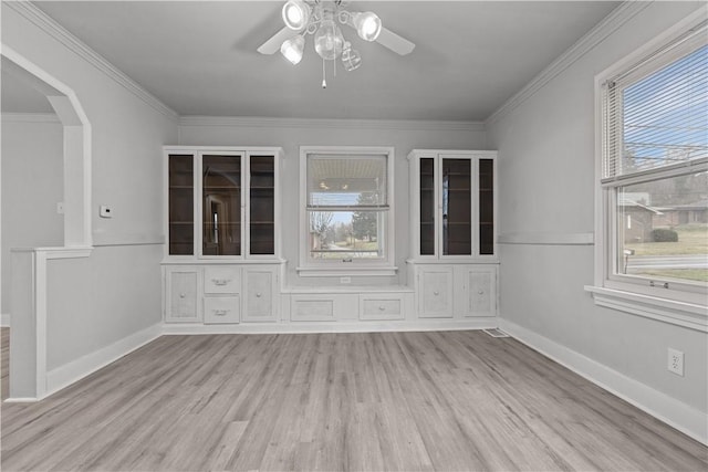 empty room with ceiling fan, light wood-type flooring, and crown molding