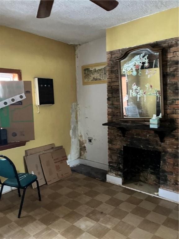 interior space featuring a textured ceiling, ceiling fan, and a fireplace